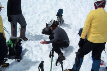 Picture of a guide discussing a snow covered mountain climb.